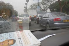 Newspaper in Nairobi reporting American President Obama reflected in car window. News from Kenya and from other countries on the continent of Africa